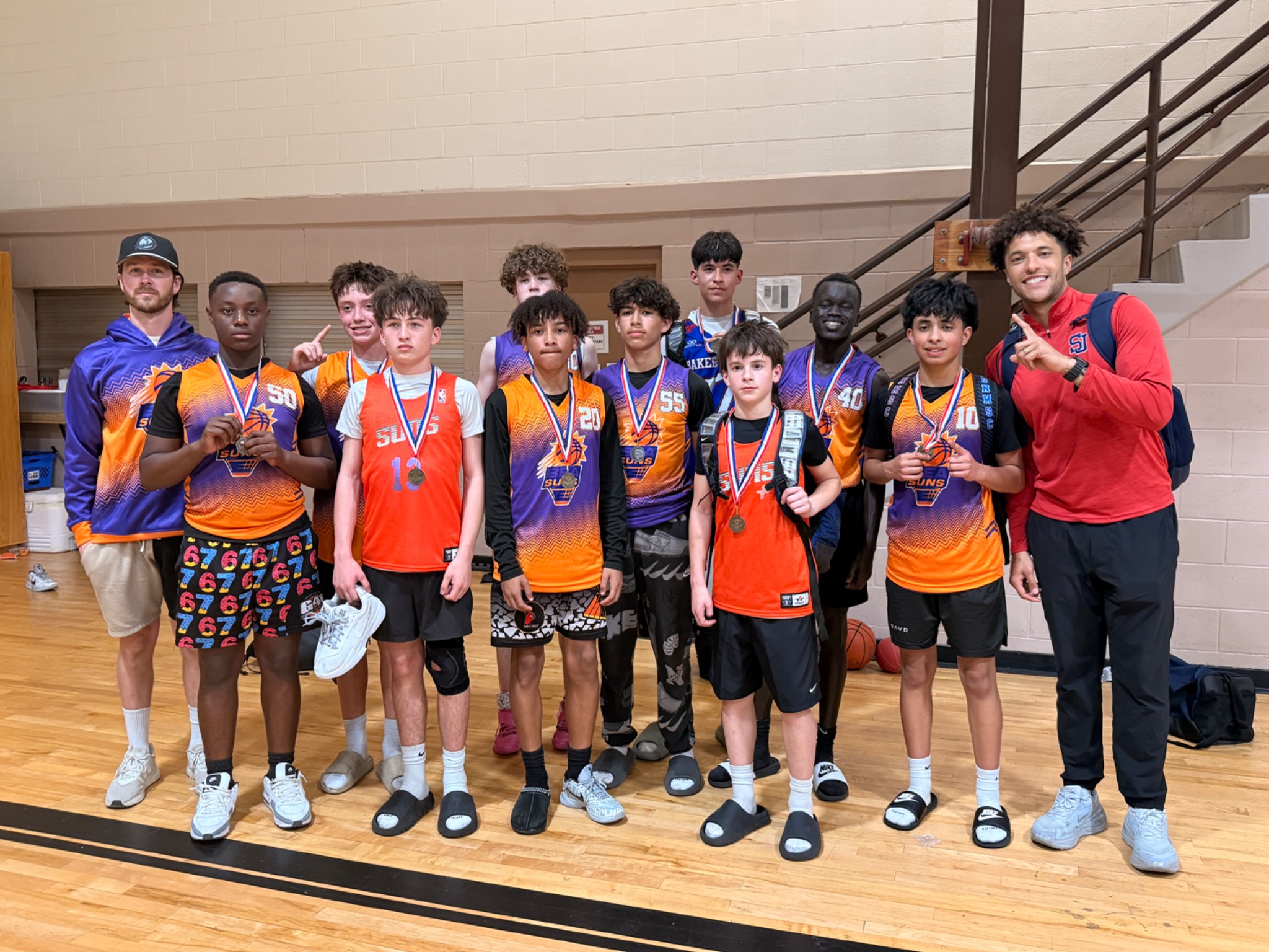 BEA Suns 7th and 8th grade group from last season posing with their coaches after a tournament
